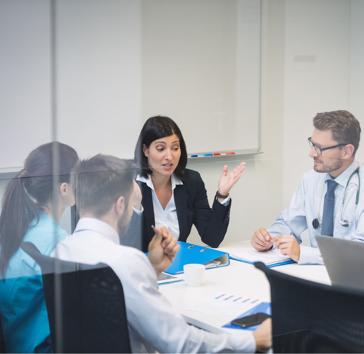 Healthcare professionals collaborating around a table during a team meeting
