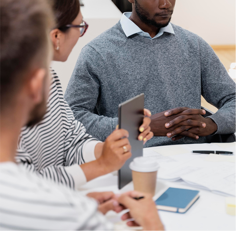 Professionals in a meeting with tablets and notes on a table