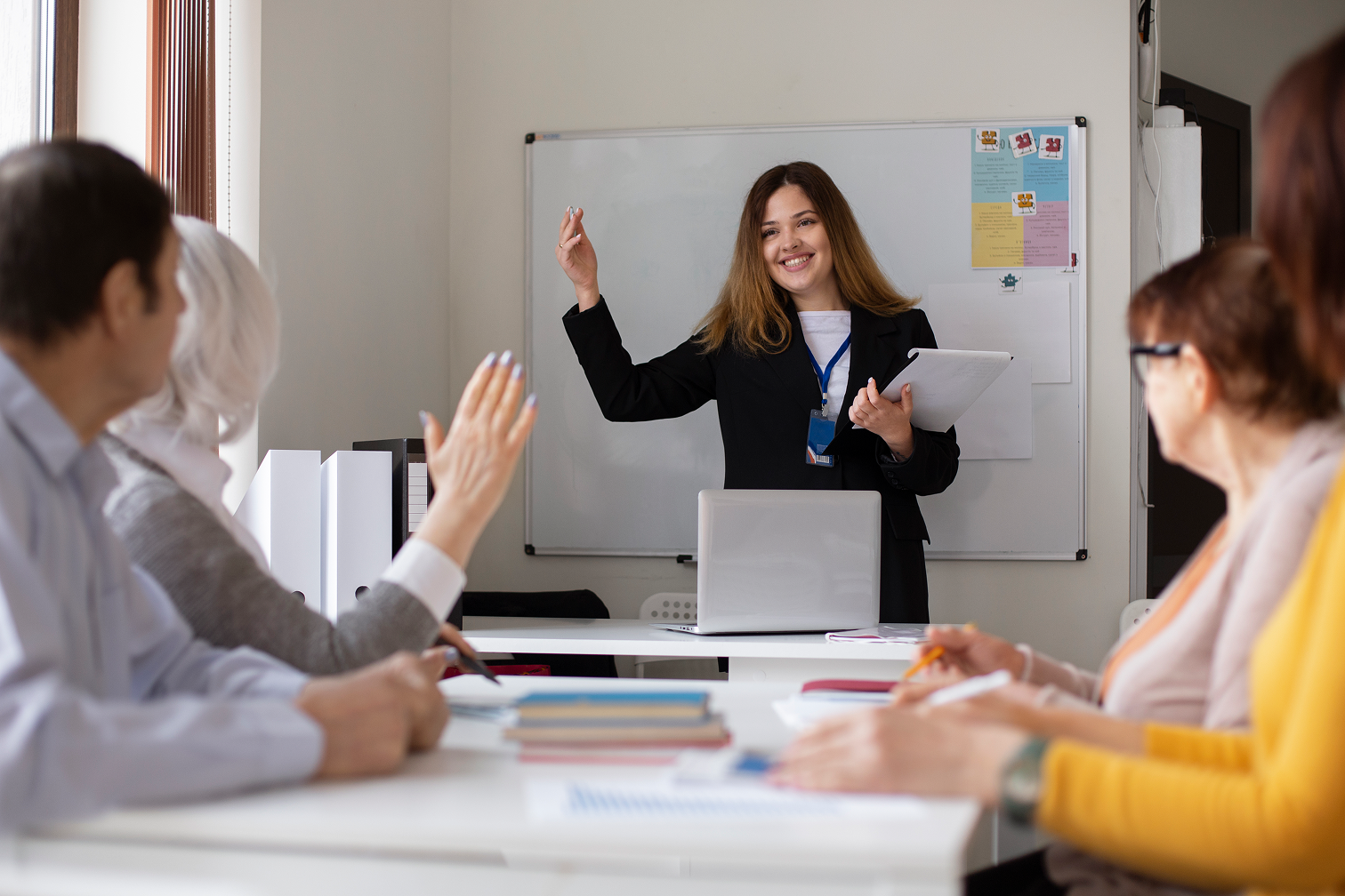 Professional presenting at a whiteboard during a team meeting