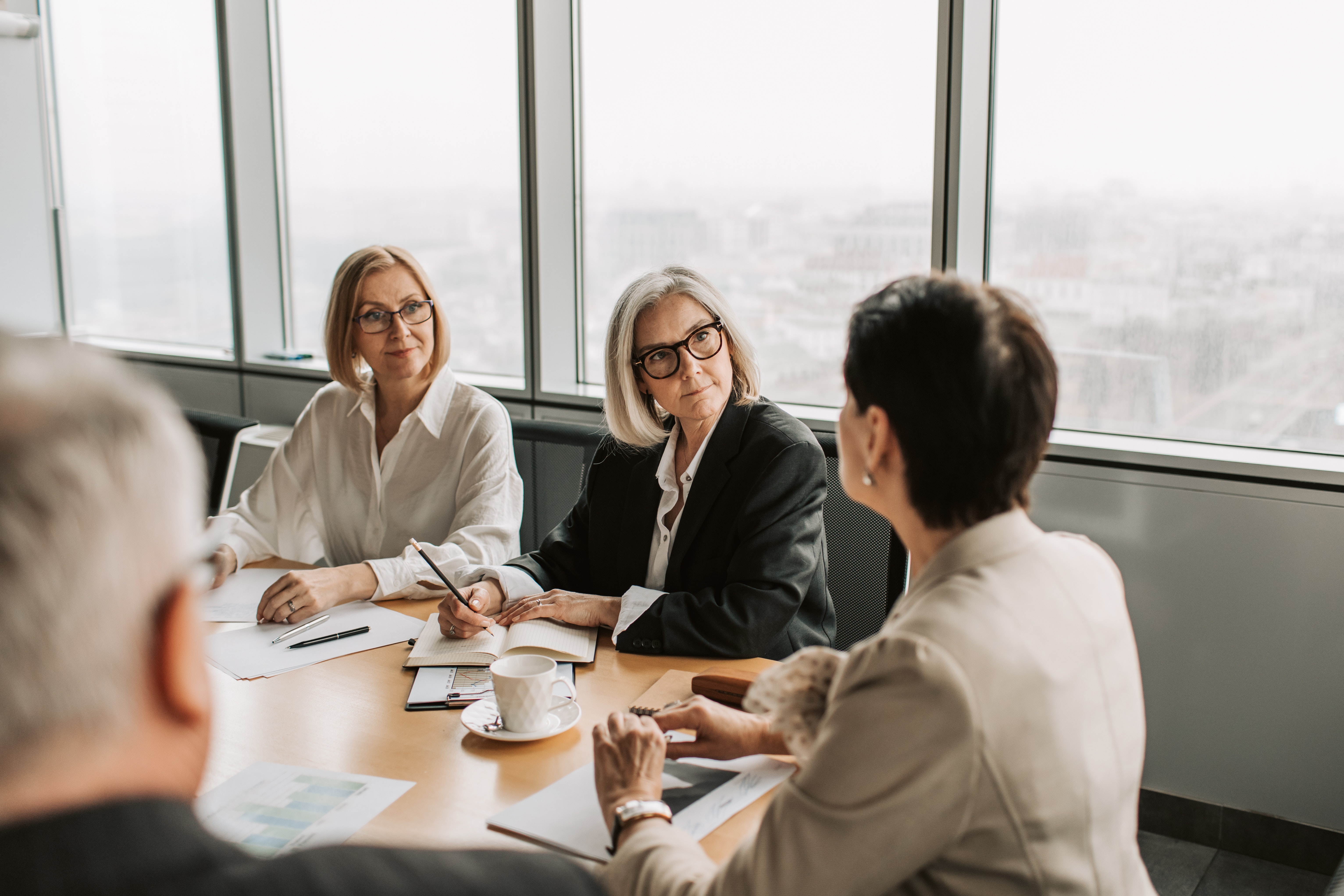 3 women sitting in a meeting room engaged in a discussion